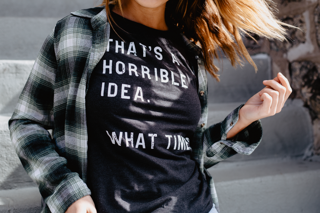 Woman wearing a That's a terrible idea. What time? printed shirt